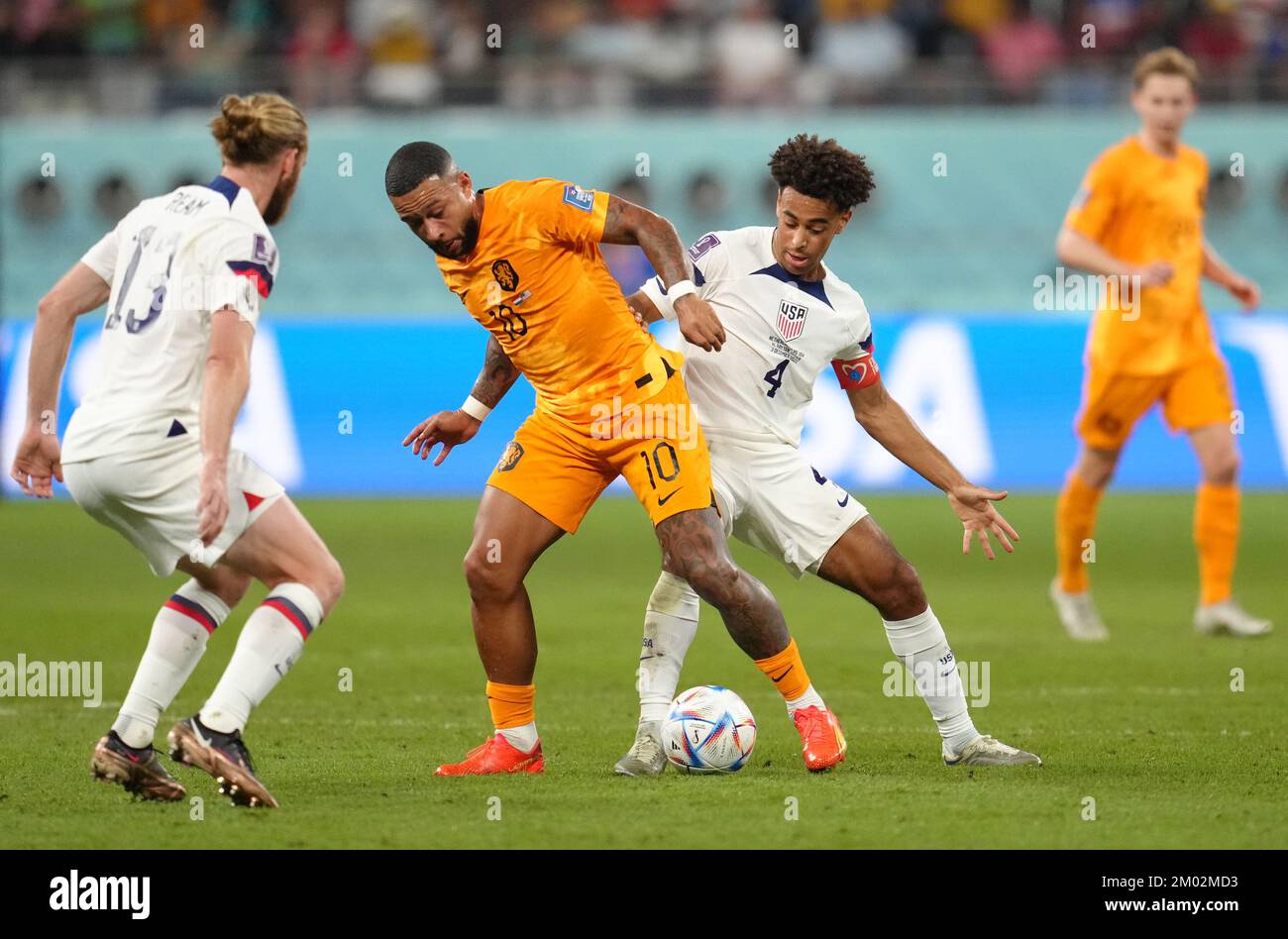 Netherlands' Memphis Depay (centre left) and USA's Tyler Adams battle for the ball during the FIFA World Cup round of 16 match at the Khalifa International Stadium in Al Rayyan, Qatar. Picture date: Saturday December 3, 2022. Stock Photo