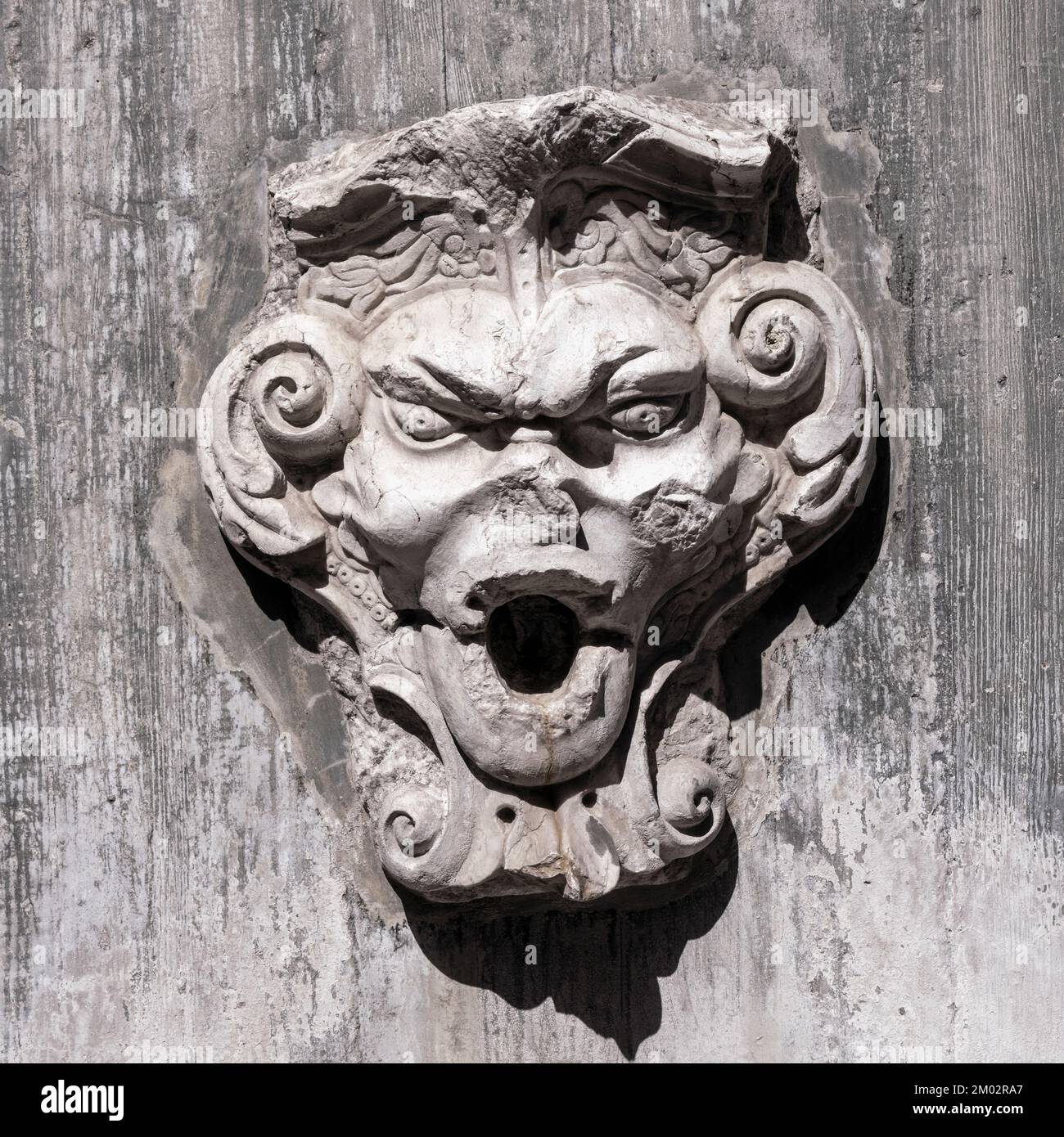 Grotesque face on a water fountain in the gardens of St George's castle, Lisbon, Portugal. Stock Photo