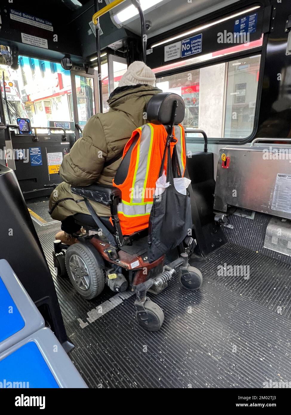 Disabled rider on a city bus prepares to disembark on her electric wheelchair in Brooklyn, New