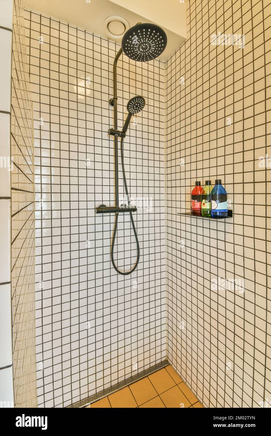 Tile partition between shower tap and wall hung toilet in modern