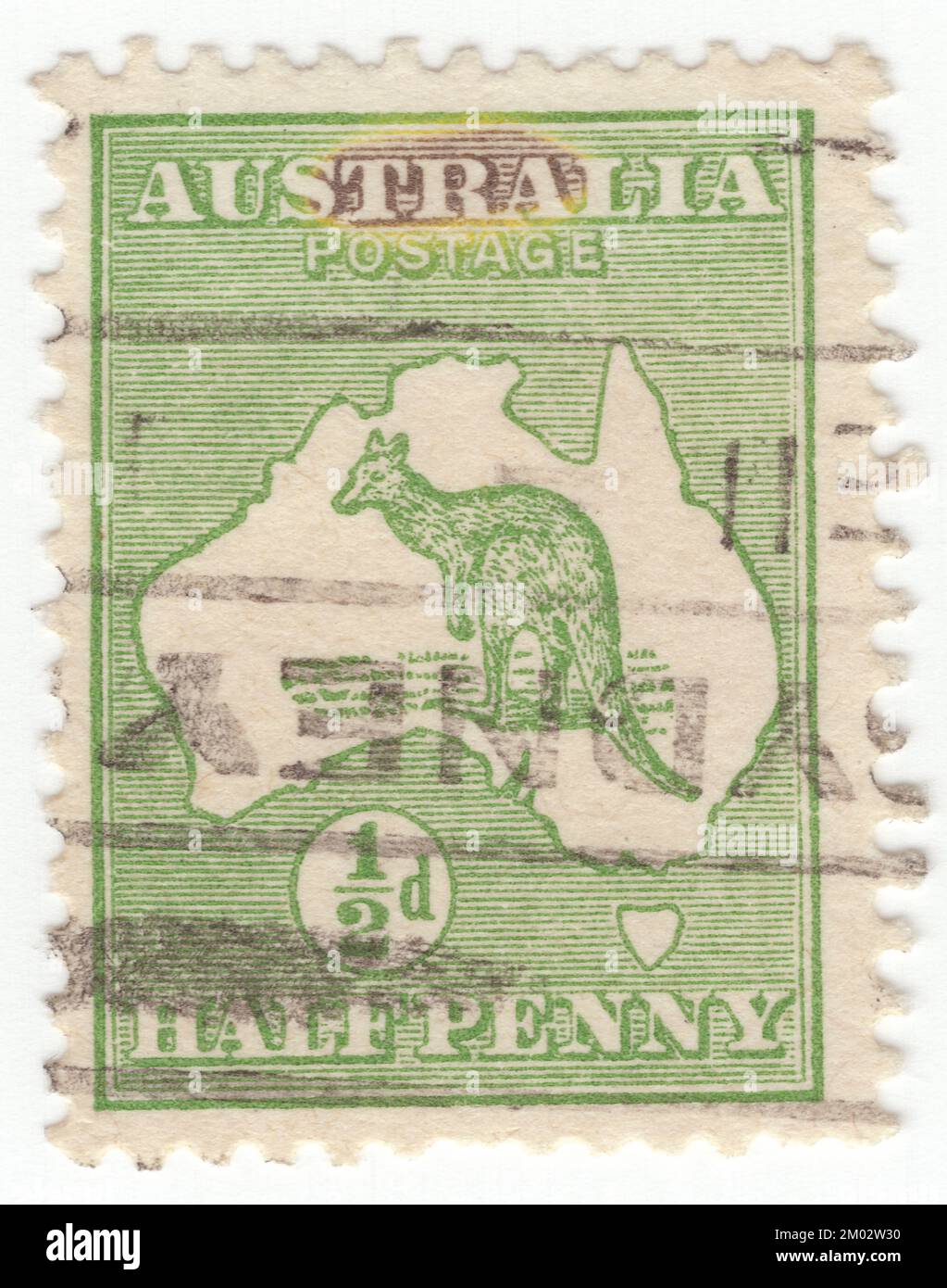 AUSTRALIA — 1913: An ½ pence green postage stamp depicting Kangaroo and Map of Australia. Australia is the oldest, flattest, and driest inhabited continent, with the least fertile soils. It is a megadiverse country, and its size gives it a wide variety of landscapes and climates, with deserts in the centre, tropical rainforests in the north-east, and mountain ranges in the south-east. The kangaroo is a recognizable symbol of Australia. First Australian postage stamps issue. The kangaroo and emu feature on the Australian coat of arms Stock Photo