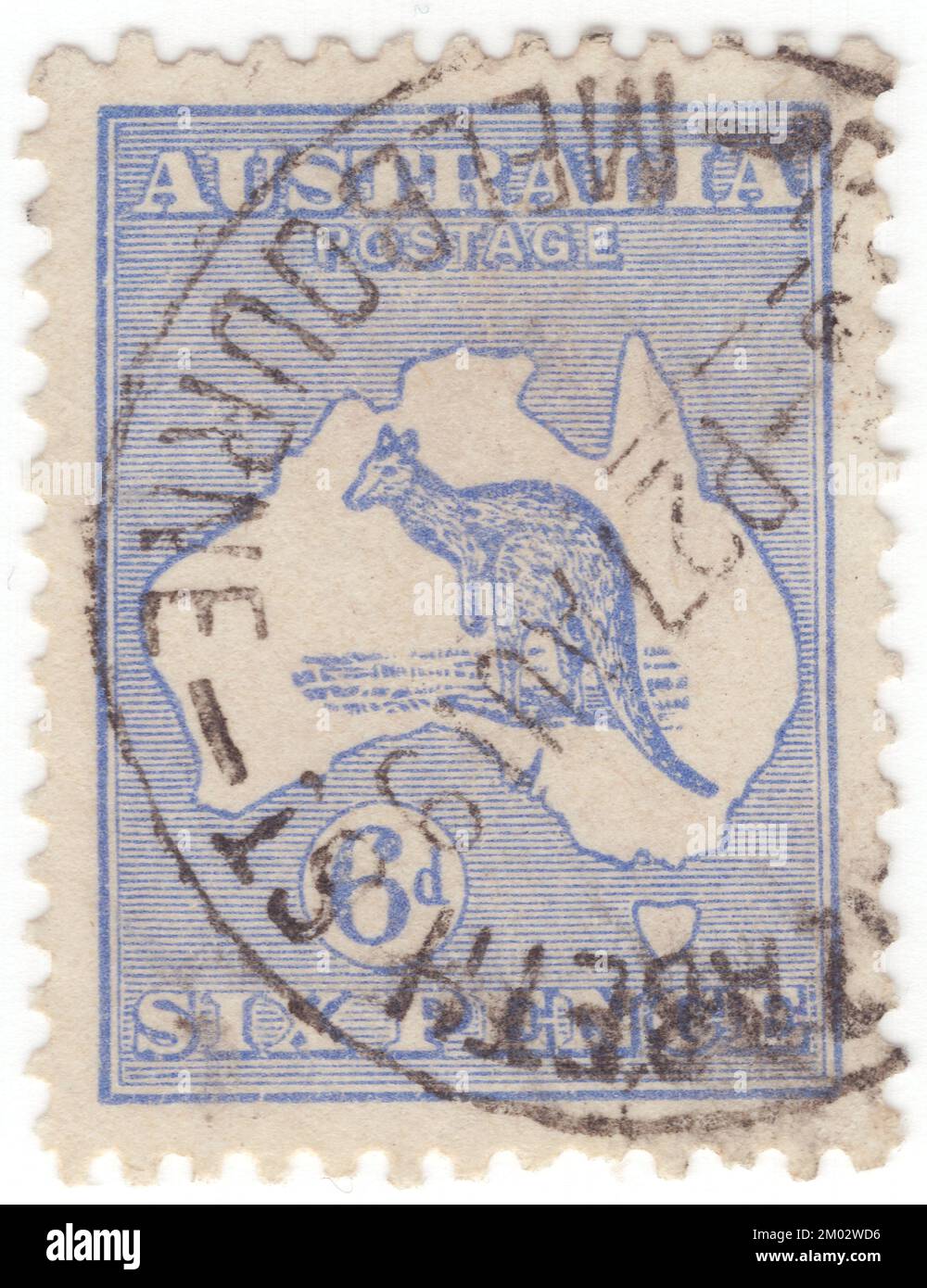 AUSTRALIA — 1913: An 6 pences ultramarine postage stamp depicting Kangaroo and Map of Australia. Australia is the oldest, flattest, and driest inhabited continent, with the least fertile soils. It is a megadiverse country, and its size gives it a wide variety of landscapes and climates, with deserts in the centre, tropical rainforests in the north-east, and mountain ranges in the south-east. The kangaroo is a recognizable symbol of Australia. First Australian postage stamps issue. The kangaroo and emu feature on the Australian coat of arms Stock Photo