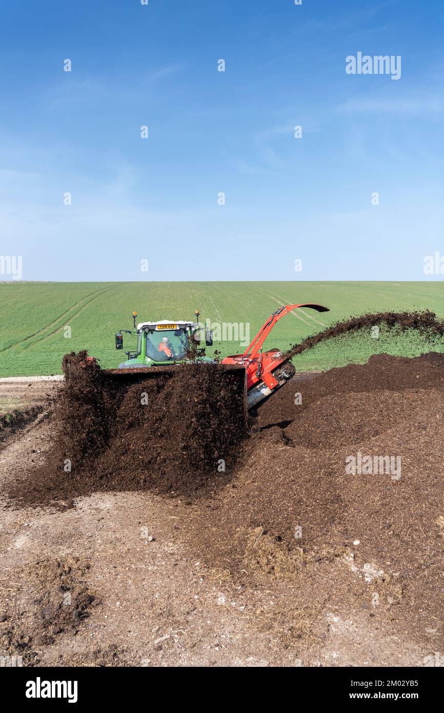 Turning a manure heap over to make compost to spread on farmland, which helps increase the quality of the soil. North Yorkshire, UK. Stock Photo