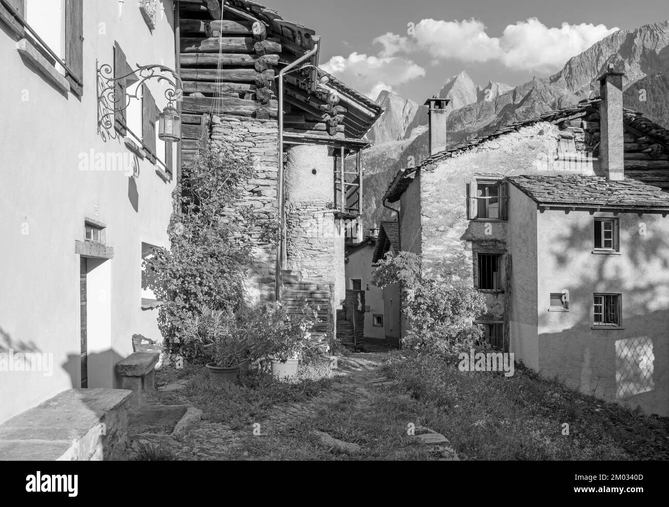 The Soglio village and Piz Badile, Pizzo Cengalo, and Sciora peaks in the Bregaglia range - Switzerland. Stock Photo