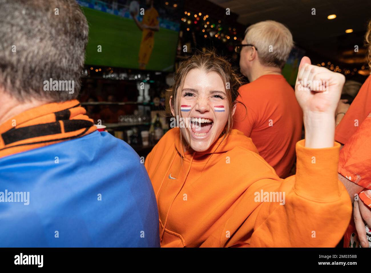 Fans of The Netherlands football team reacting and drinking during the game against USA at Qatar World Cup at Hurley's Saloon in New York on December 3, 2022 Stock Photo