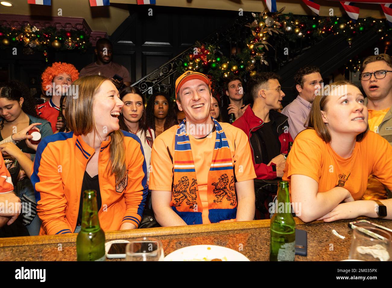Fans of The Netherlands football team reacting and drinking during the game against USA at Qatar World Cup at Hurley's Saloon in New York on December 3, 2022 Stock Photo