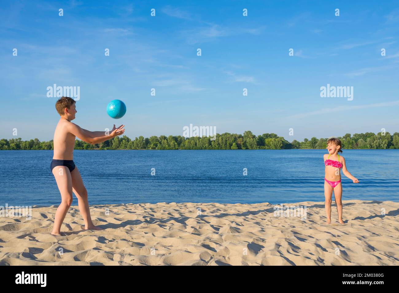 Happy children on the beach play with a ball. Summer holidays. Lifestyle Stock Photo