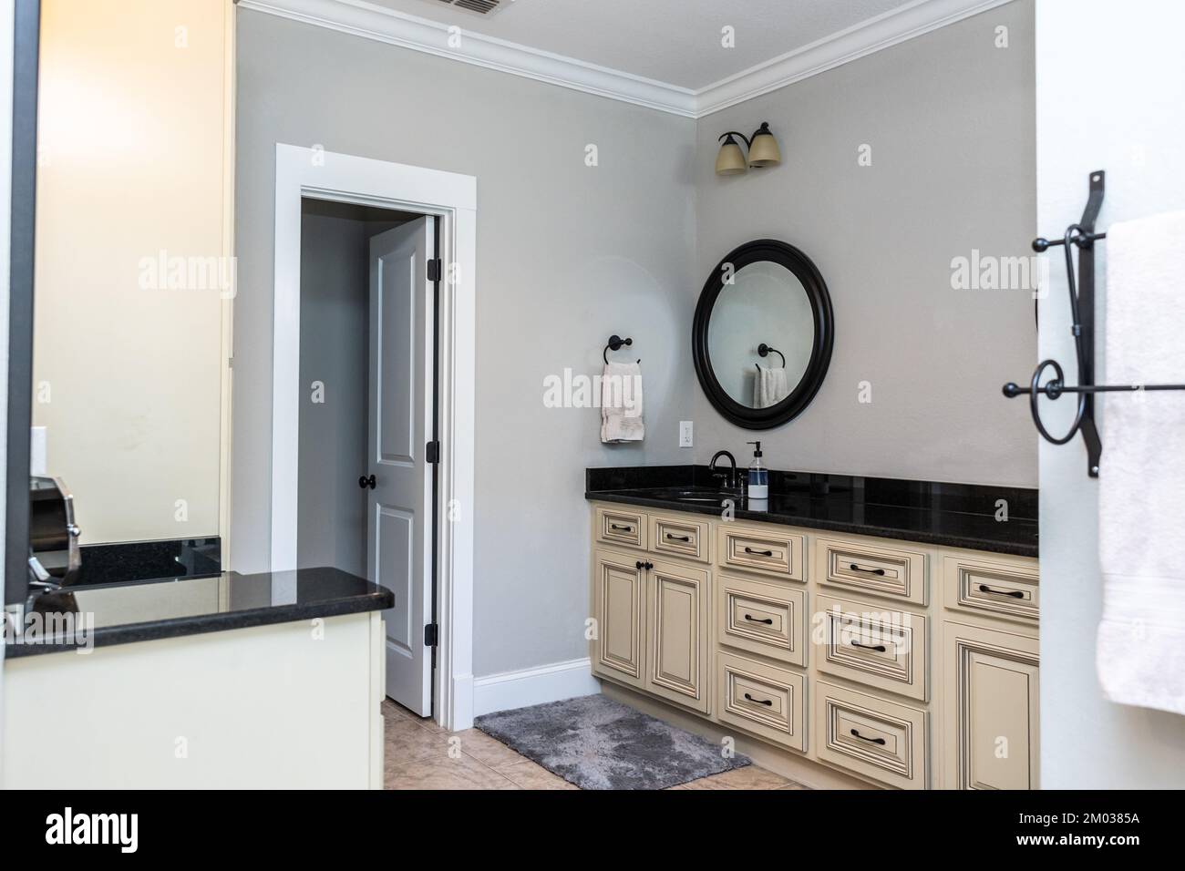 A double bathroom vanity with black granite counter tops and cream