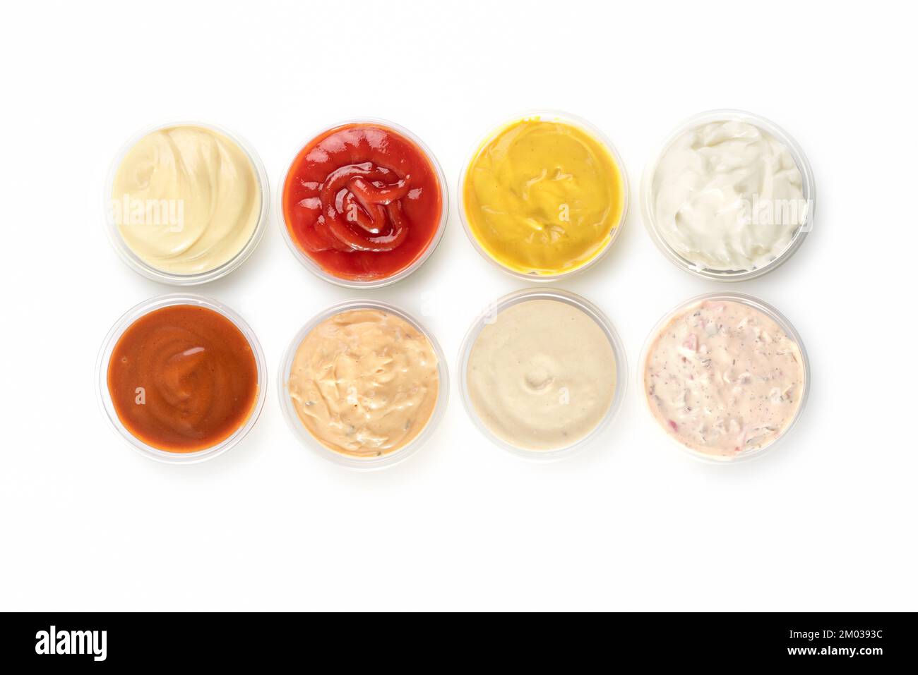 Different types of sauces in bowls on a white background. Top view