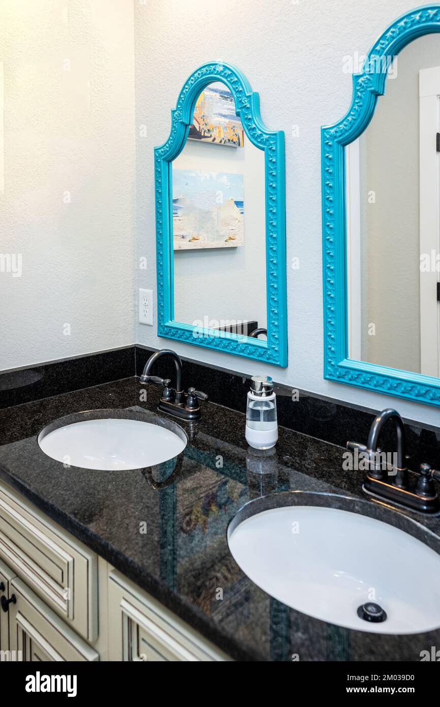 A cream and black granite jack and jill bathroom with double sinks Stock Photo
