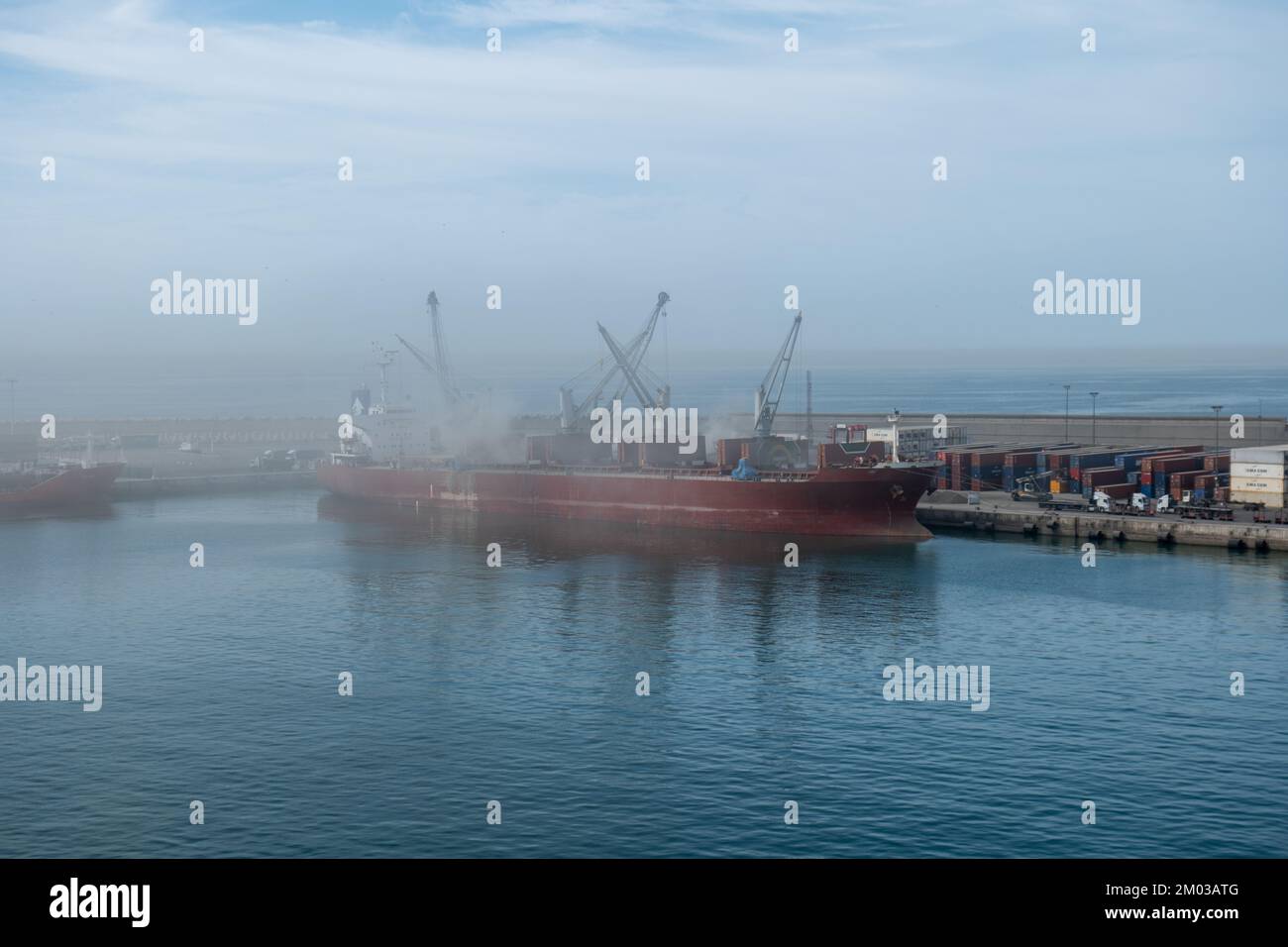 Industrial port of Agadir with ship at dock (poor visibility due to dust, sand etc.) Stock Photo