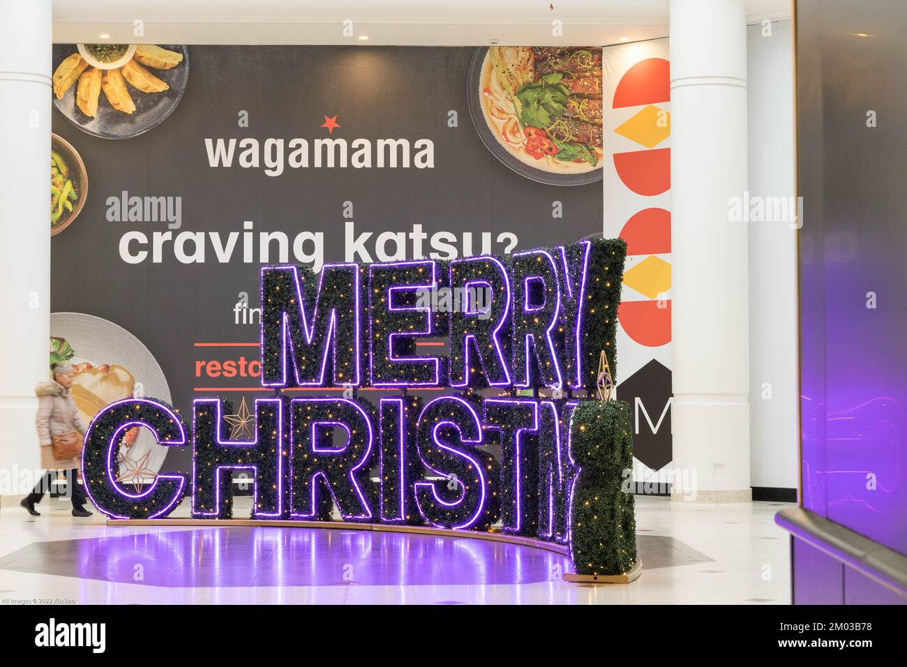 London shopping mall is decorated with Merry Christmas tree and lights outside Wagamama restaurant England UK Stock Photo