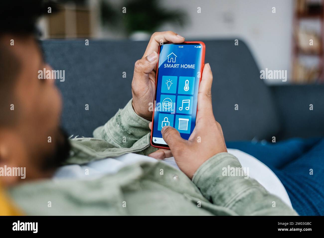 Internet of things. Young latin man using smart home app on mobile phone Stock Photo