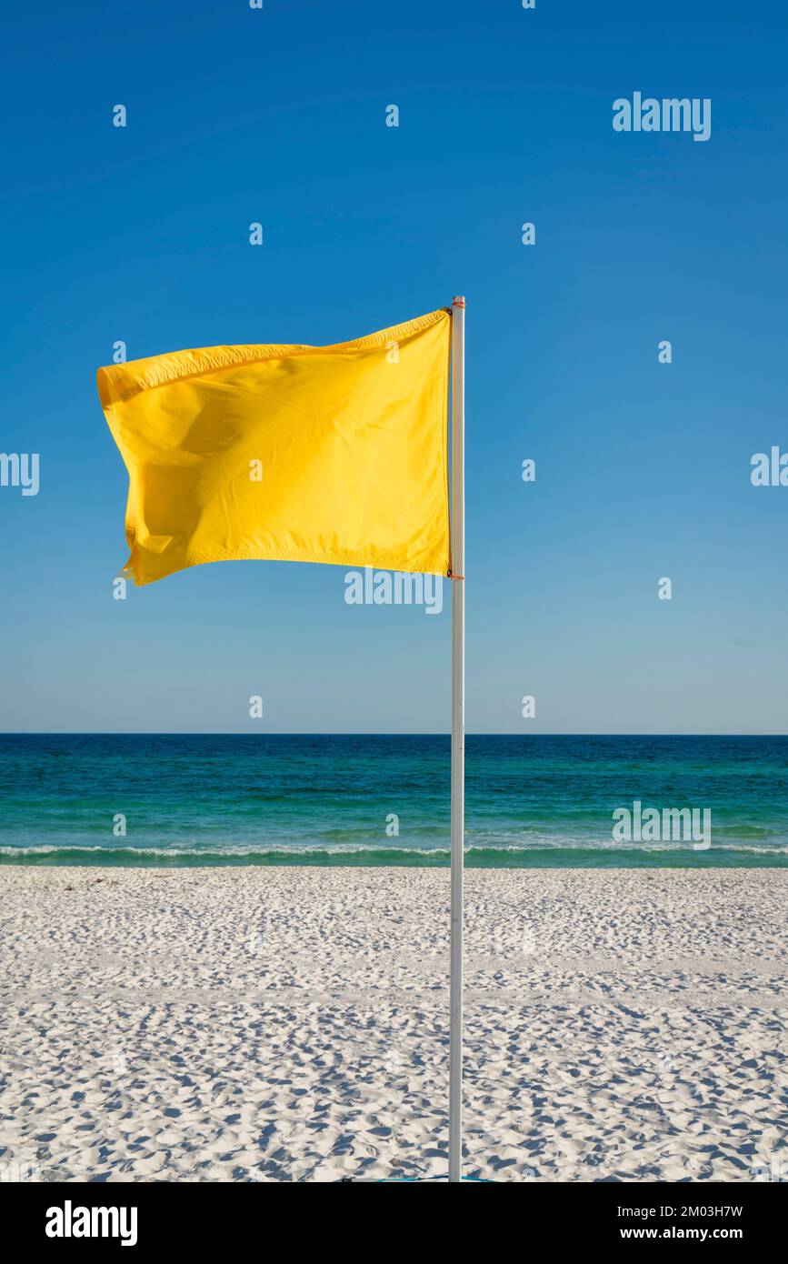 Yellow flag on a pole at the beach in Destin, Florida. Vertical shot of