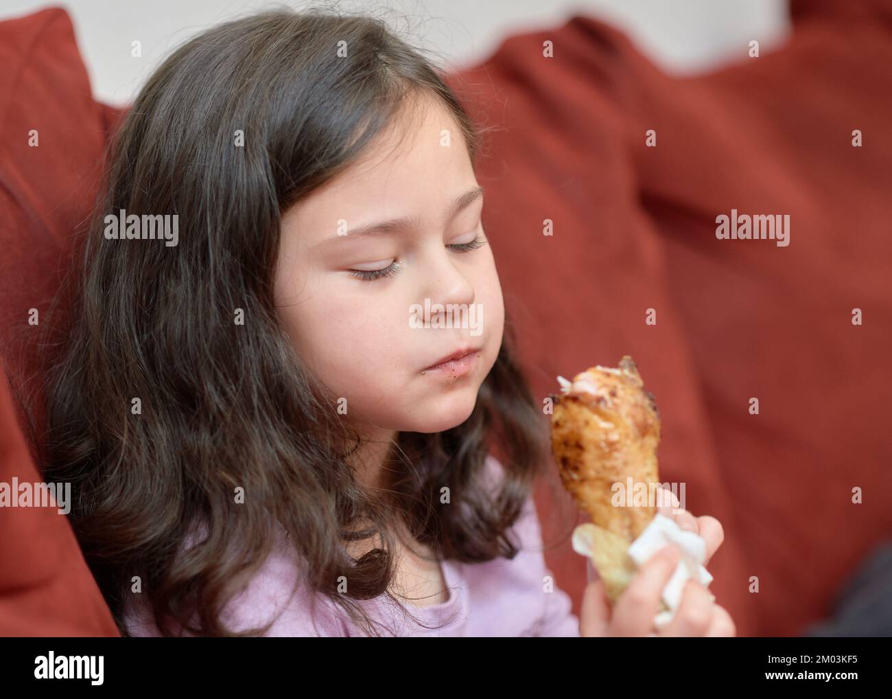 expressive young girl is eating chicken and vegetables for dinner on