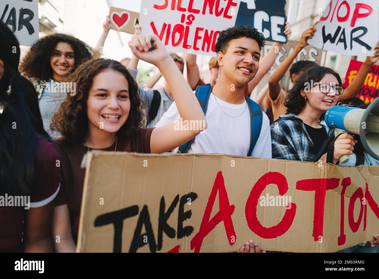 Group of happy youth activists marching for peace and human rights. Multicultural young people protesting against war and violence. Youth demonstrator Stock Photo
