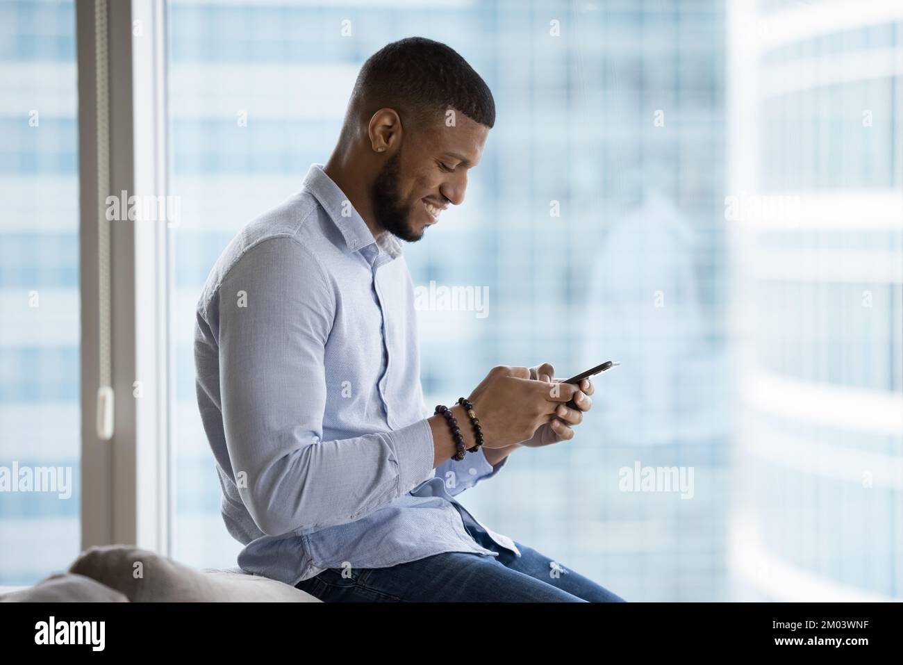 Cheerful African mobile phone user man using online app Stock Photo