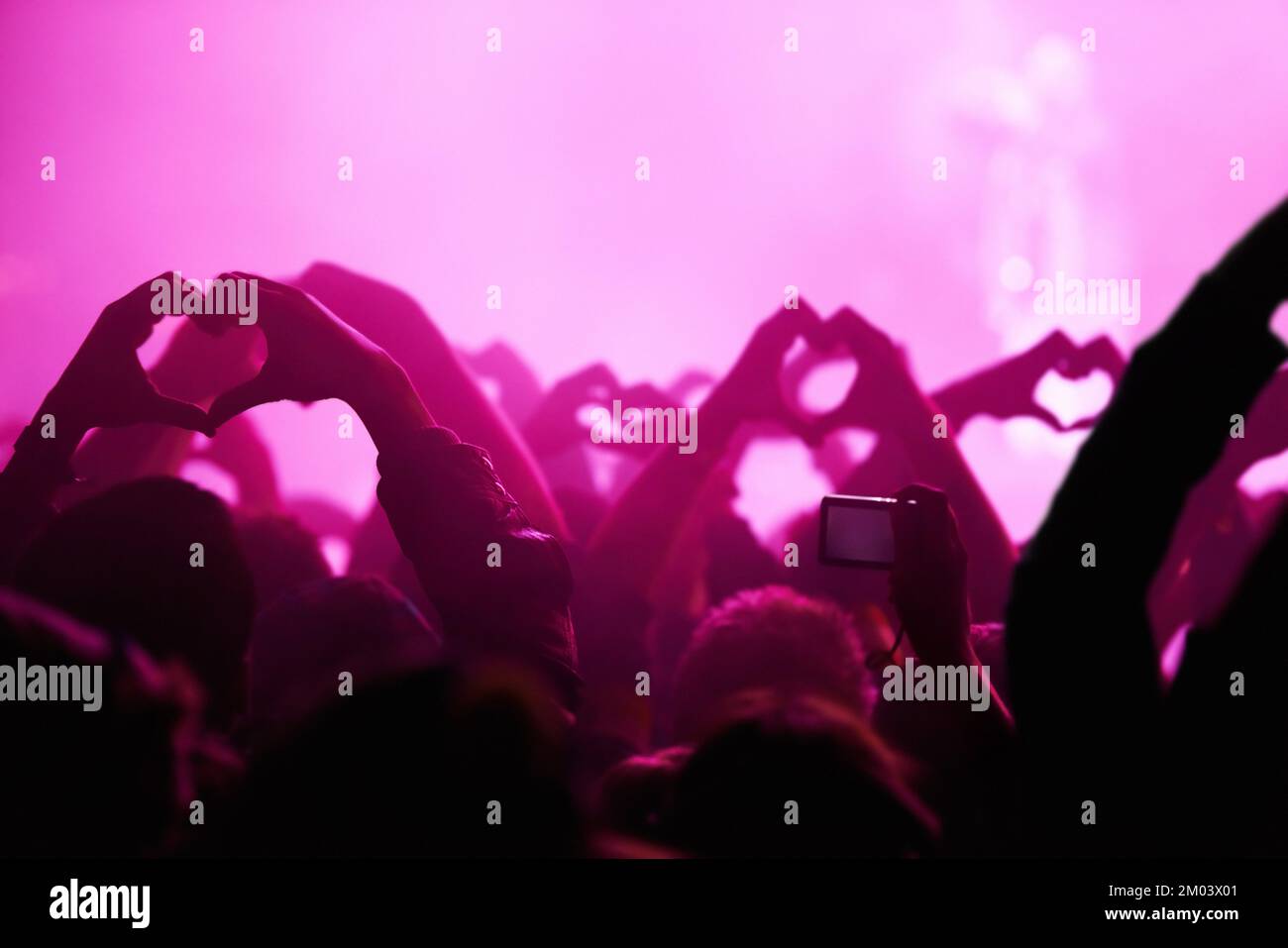 Together as one. Rear view of an audience making heart-shapes with their hands. Stock Photo