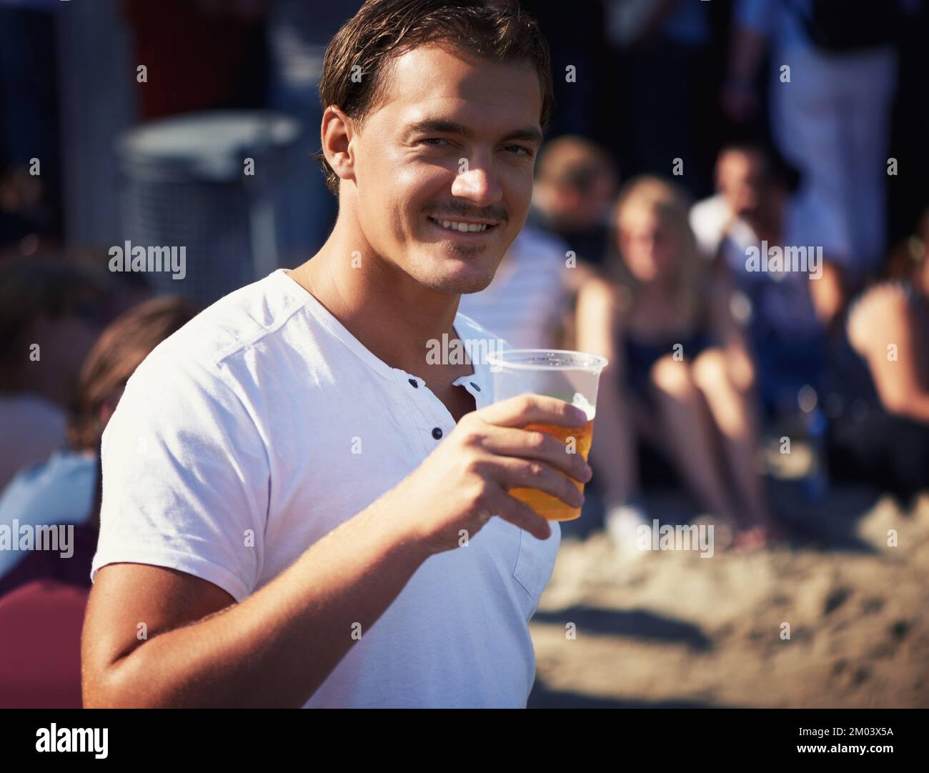 Crisp and fresh. Portrait of a young man enjoying a cool, crisp beer at a music festival. Stock Photo