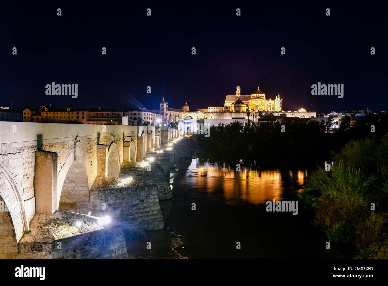 View of the Roman Bridge, a stone bridge that spans the river Guadalquivir in Cordoba, Spain at night. Stock Photo