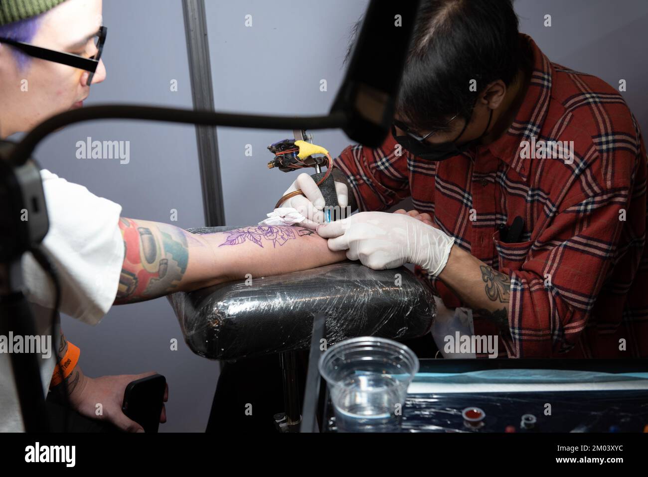 Bangkok, Thailand. 3rd Dec, 2022. A tattoo artist puts tattoos on the body of people who are