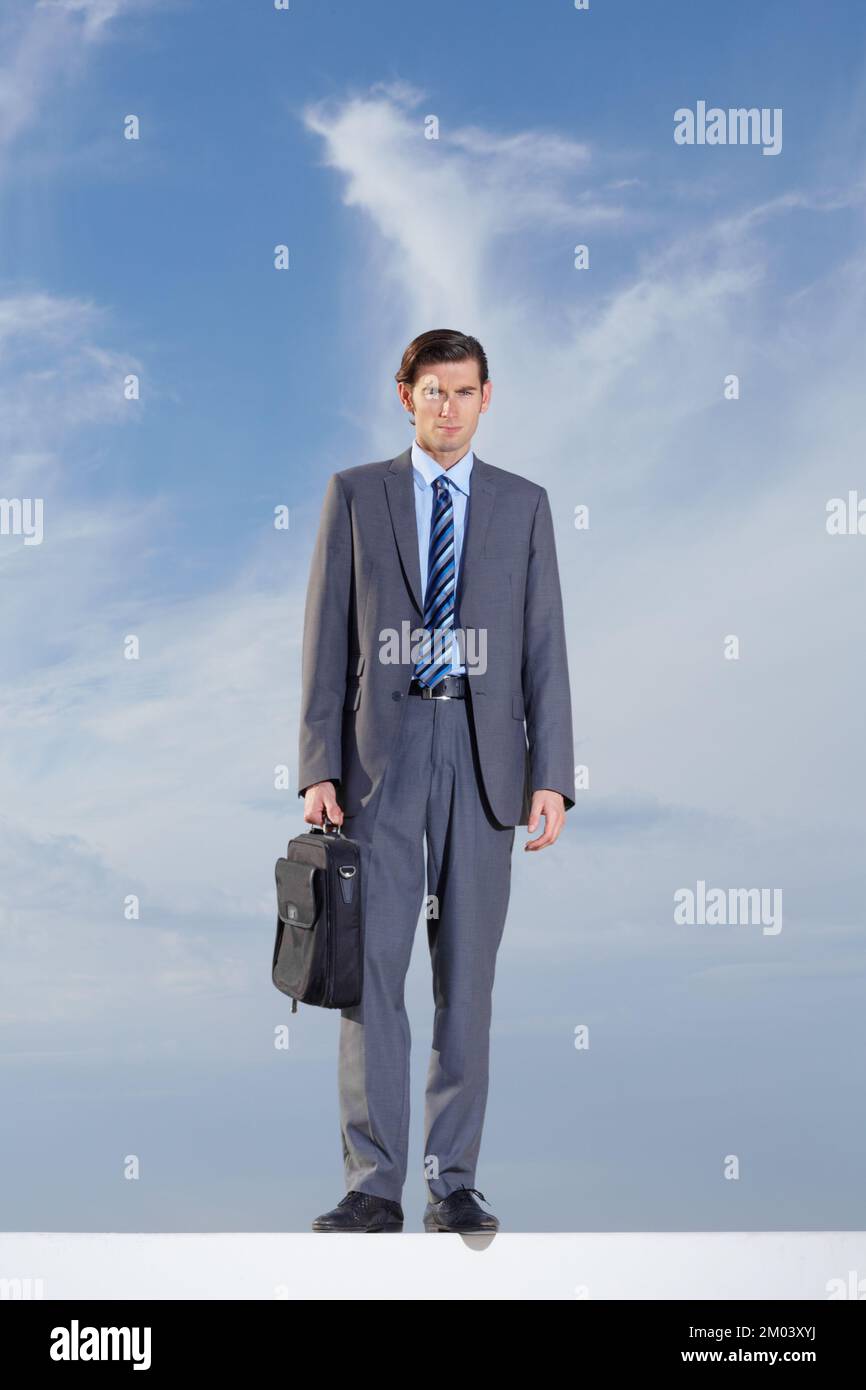 The corporate world is full of opportunity. Full body of a serious businessman standing against a blue sky. Stock Photo