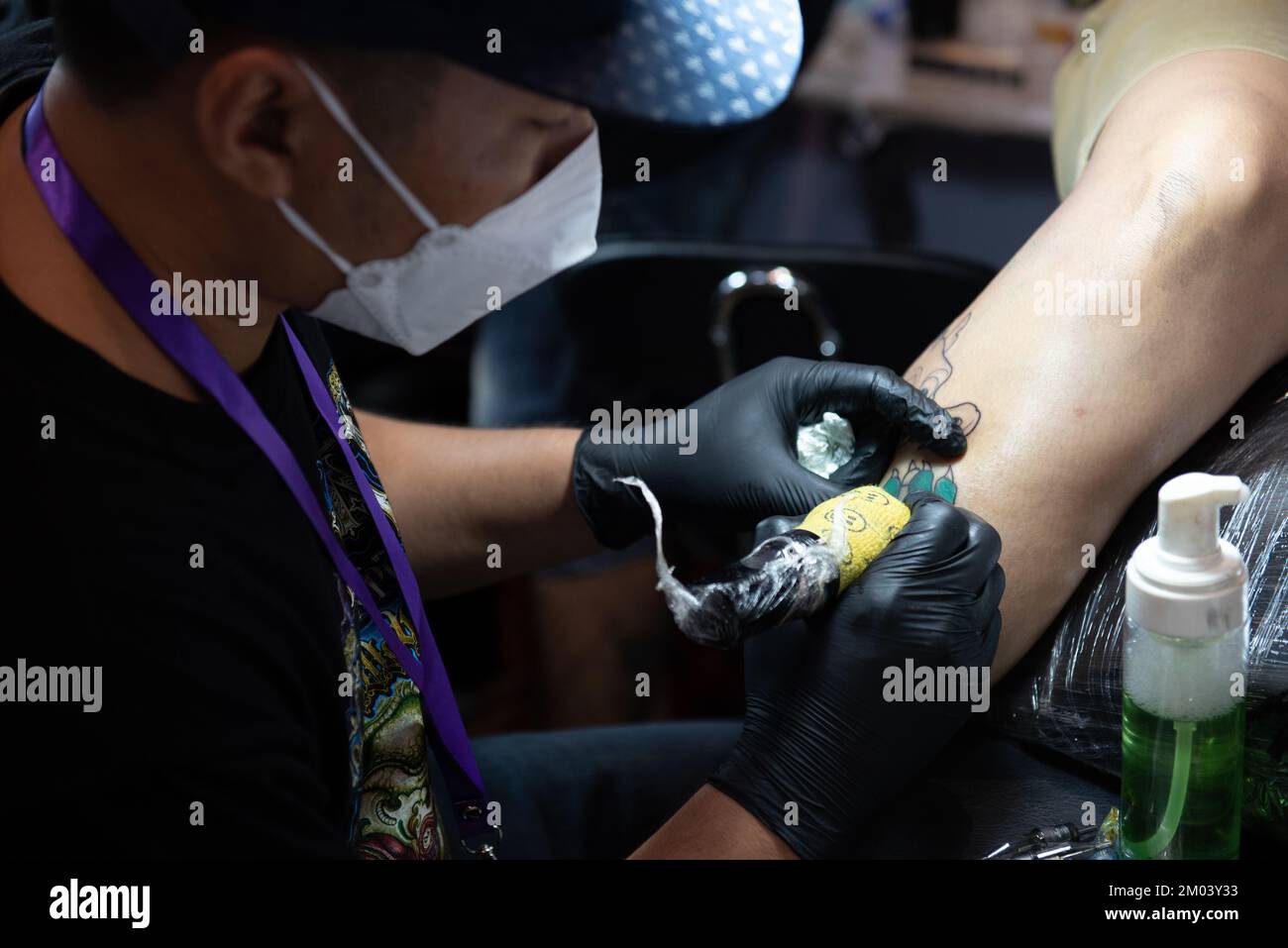 Bangkok, Thailand. 3rd Dec, 2022. A tattoo artist puts tattoos on the body of people who are