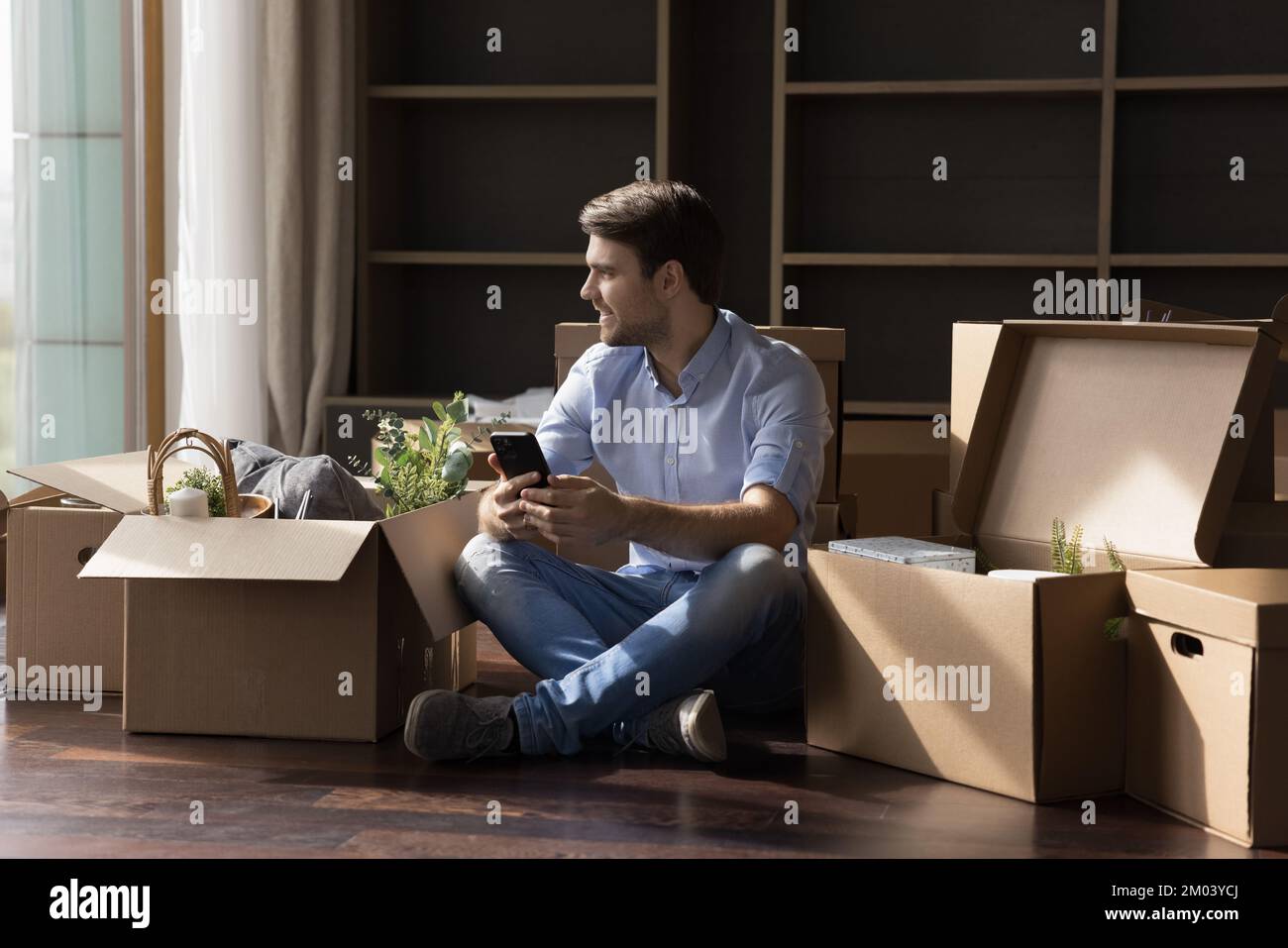 Cheerful dreamy homeowner guy buying furniture on internet store Stock Photo