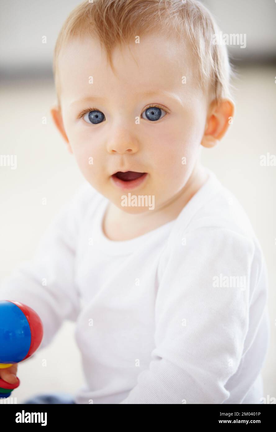 Playing and learning...Portrait of an adorable baby boy smiling at the camera while playing. Stock Photo