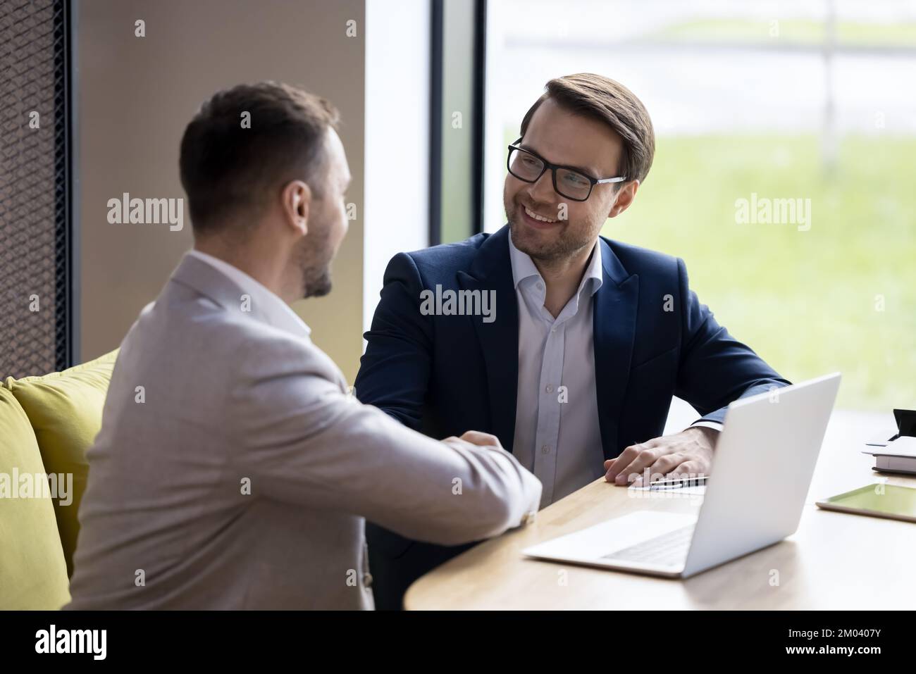 Businessmen shake hands close deal after successful negotiations in office Stock Photo