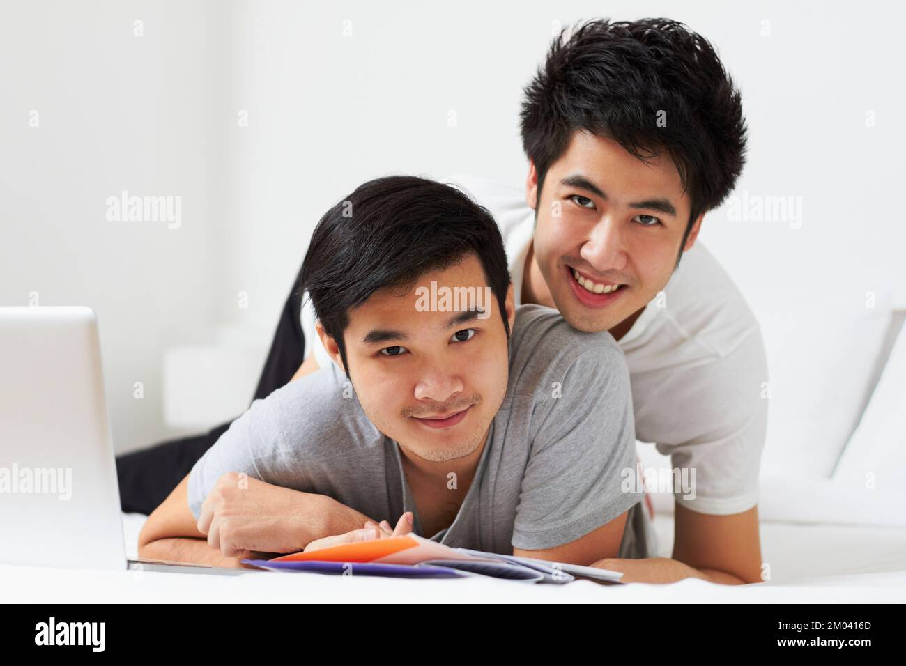 Spending the day together. Portrait of a young gay couple relaxing in bed. Stock Photo