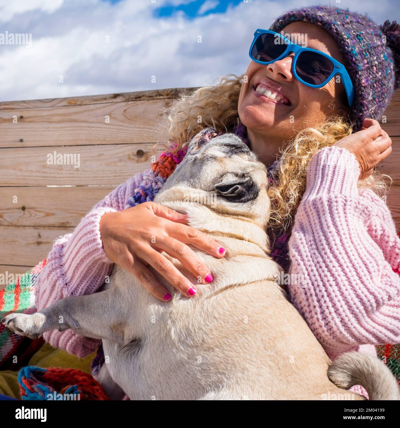 One joyful woman play with her dog best friend forever. Female people playing with pug puppy and having fun together. People and animals funny moments Stock Photo