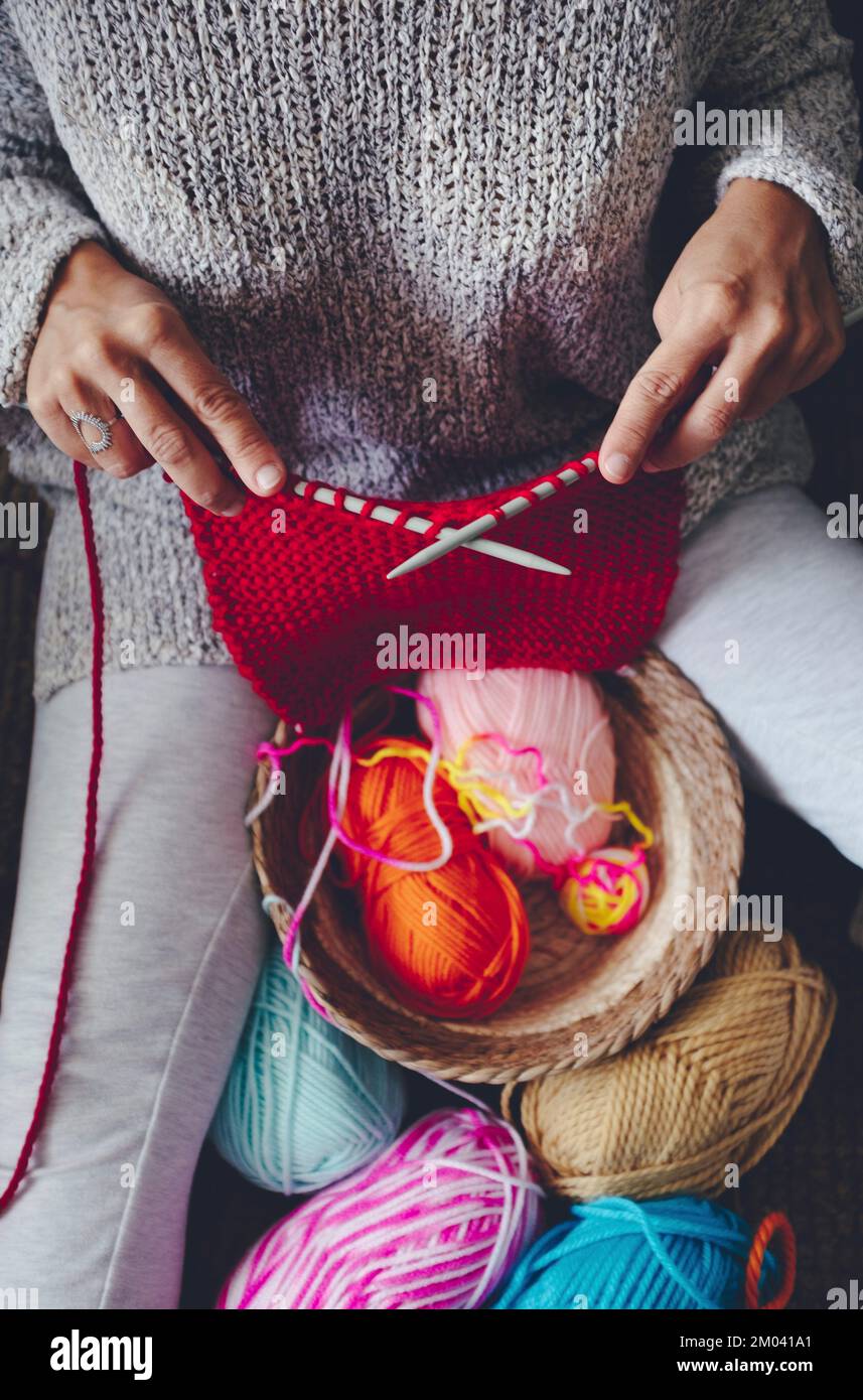Above view of woman doing knit work leisure activity at home indoor. Knitting with colorful wool. Making garment home made art style. People and hobby Stock Photo
