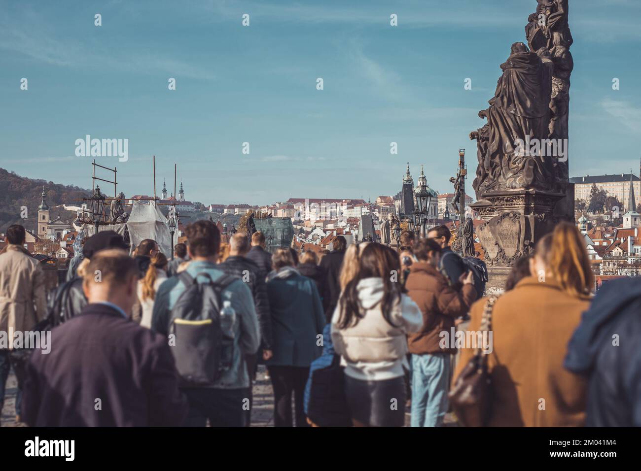 Multitude of people on charles bridge in prague, with the view towards the famous hradcani hill on a crowded autumn day. Stock Photo