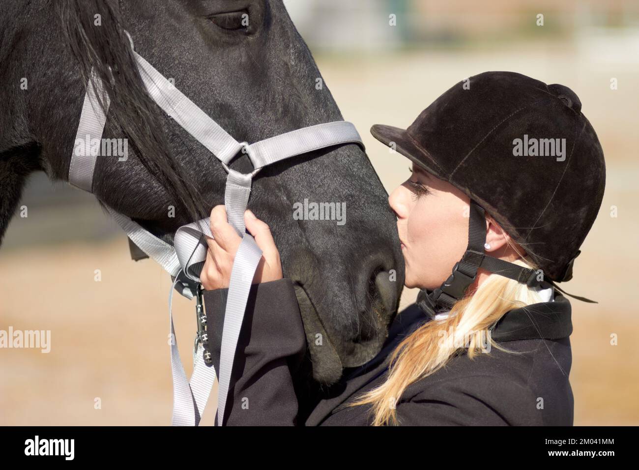 A strong bond between horse and rider. a young female rider giving her horse a kiss. Stock Photo