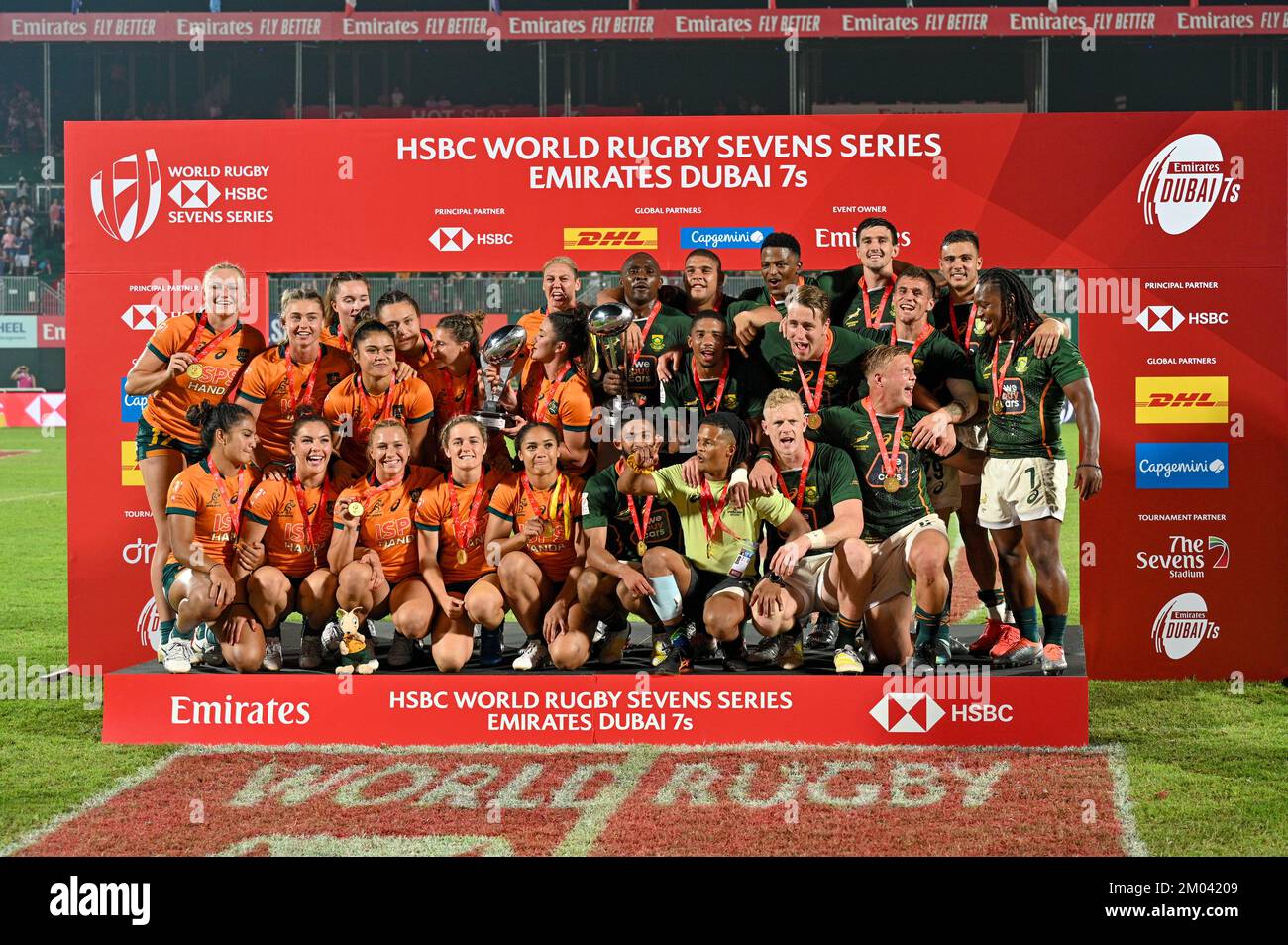 DUBAI, UAE, 3rd Dec 2022. The Australian Women’s team and South African men's team pose for pictures after their victories at the 2022 Dubai Rugby 7s. The event is part of the 2022 HSBC World Rugby Sevens Series Credit: Feroz Khan/Alamy Live News Stock Photo