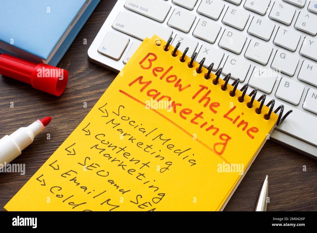 Marks about Below the line BTL marketing in the yellow notepad. Stock Photo
