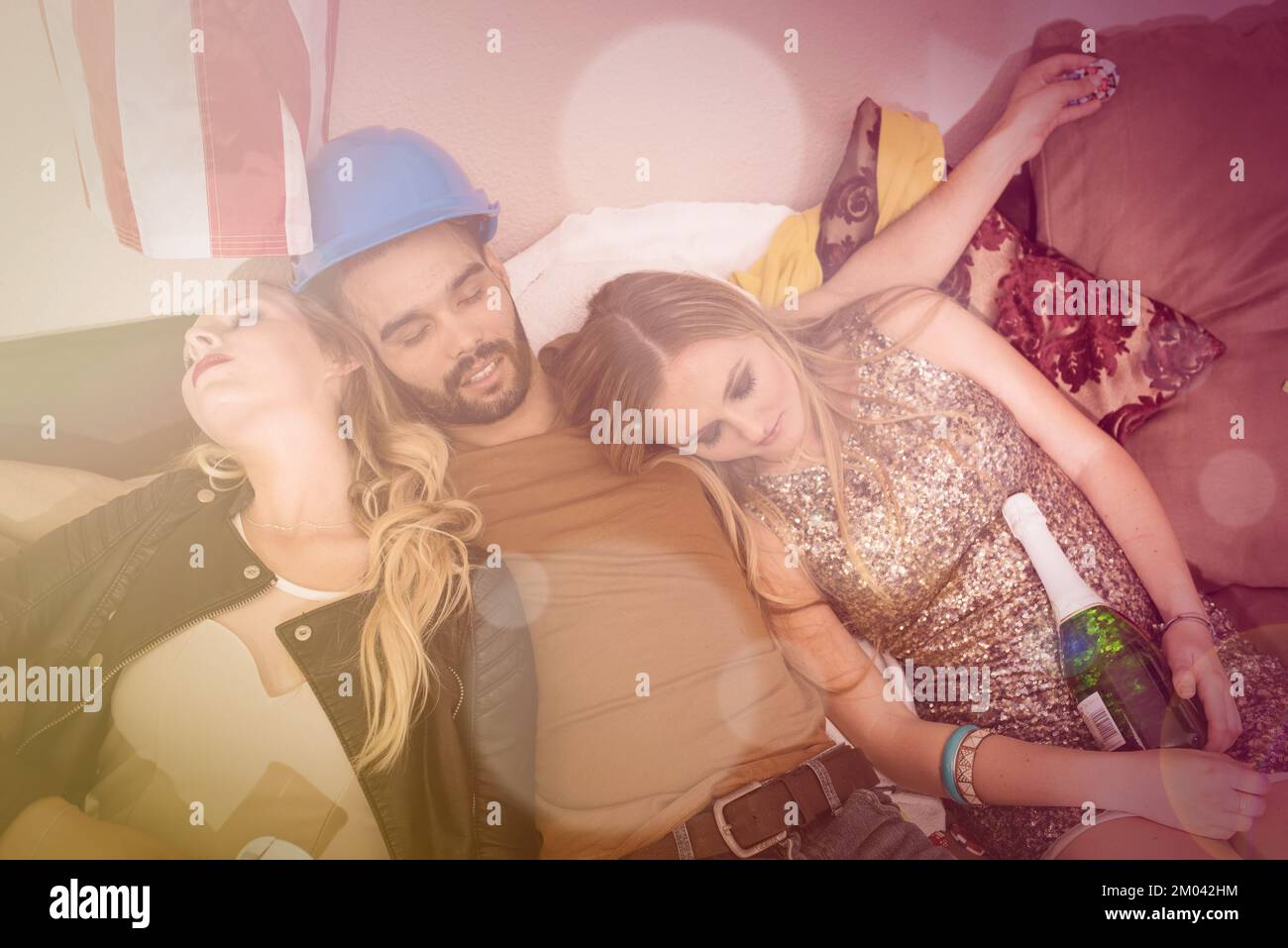 Sleeping, drunk and party with friends on sofa with hangover from celebration, social and spring break. New year, festive and champagne with people Stock Photo