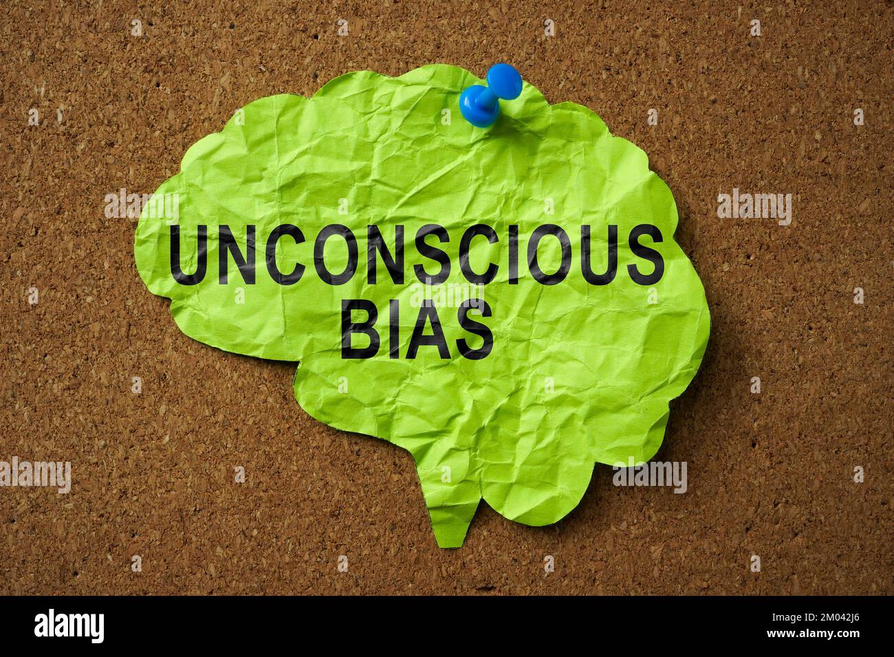 Brain made of paper with the inscription Unconscious Bias pinned to the board. Stock Photo