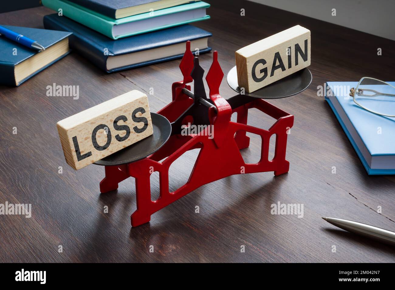 Small scales with inscriptions loss and gain on the table. Loss Aversion Bias concept. Stock Photo