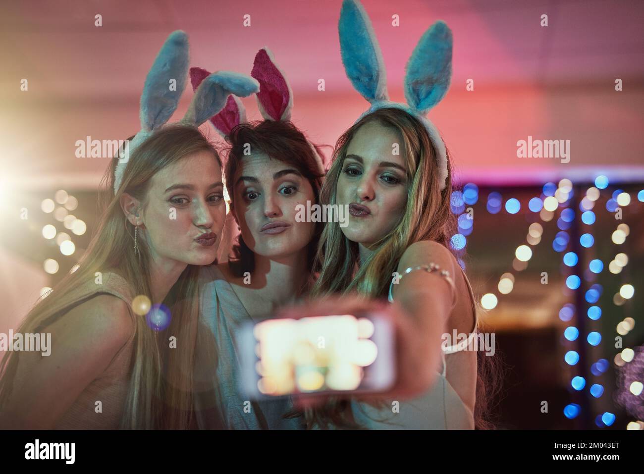 party, technology, nightlife and people concept - smiling friends with  smartphone taking selfie in club. Stock Photo