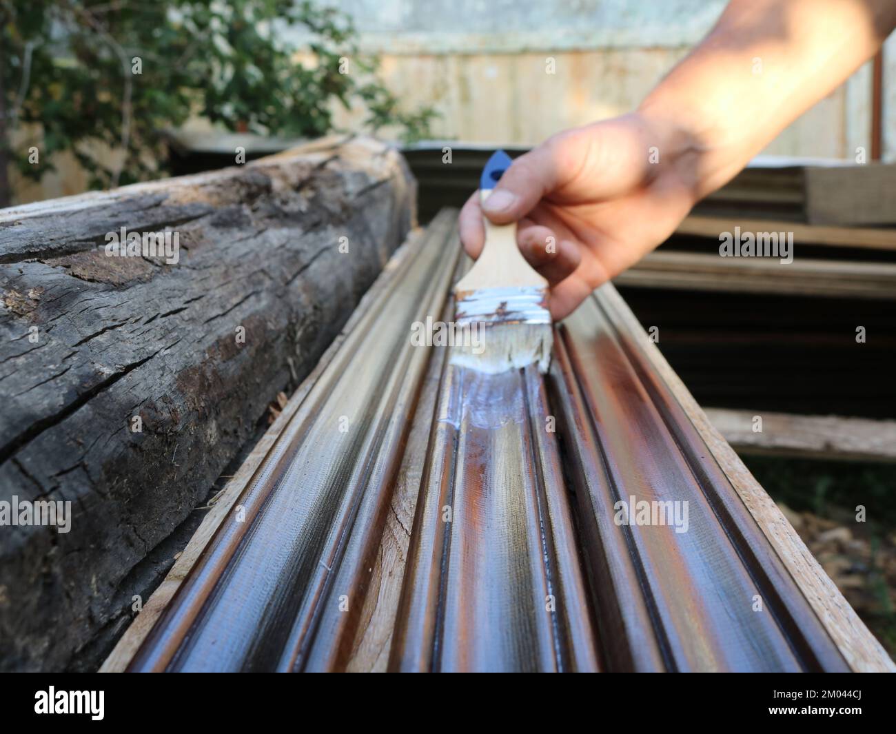 several dark stained long planks in the process of varnishing a