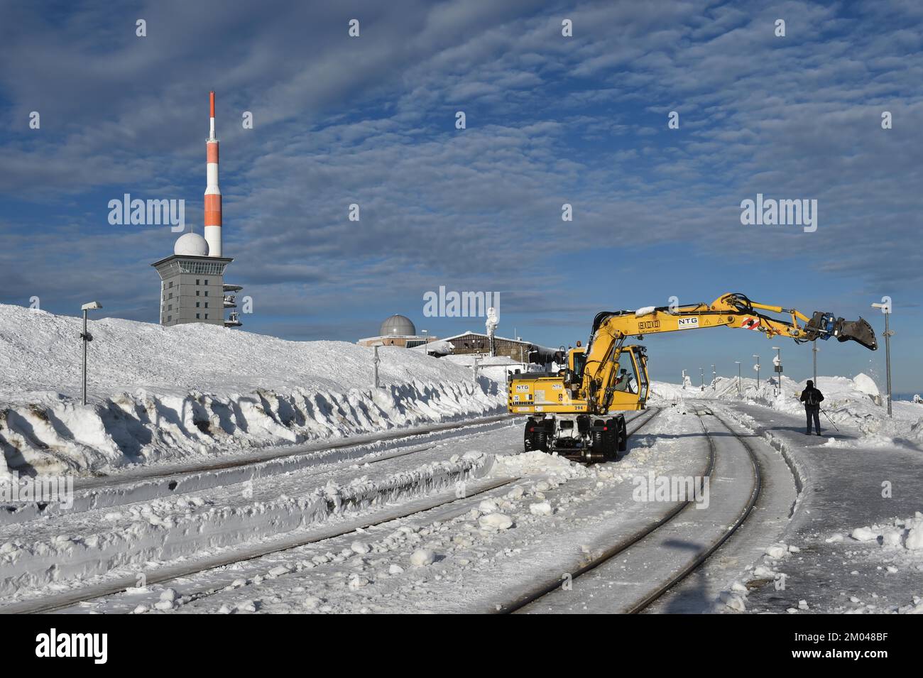 Two-way excavator clears the tracks of snow at Brocken railway station in the Harz mountains, Saxony-Anhalt, Germany, Europe Stock Photo
