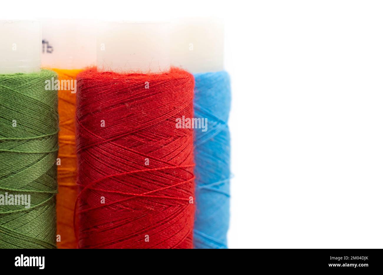 Spools of colored threads on a white background with an empty space for ...