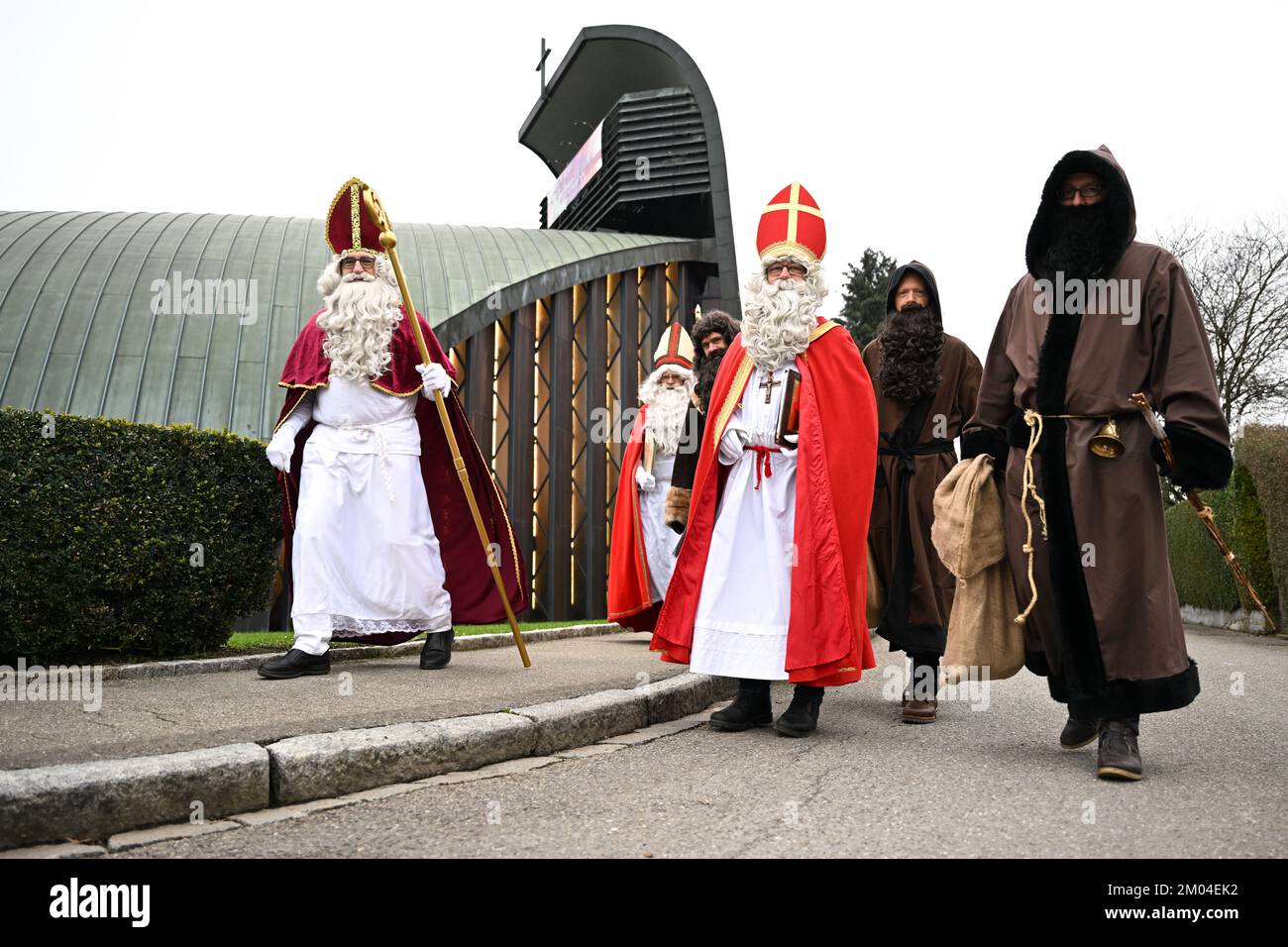 Friedrichshafen, Germany. 04th Dec, 2022. Members of the St. Nicholas Guild Friedrichshafen walk dressed as St. Nicholas and Knecht Ruprecht to the Catholic church 'Zum guten Hirten', from where they are sent out. In the days leading up to the 4th of Advent, the guild visits around 150 families, clubs, kindergartens and care facilities. Credit: Felix Kästle/dpa/Alamy Live News Stock Photo