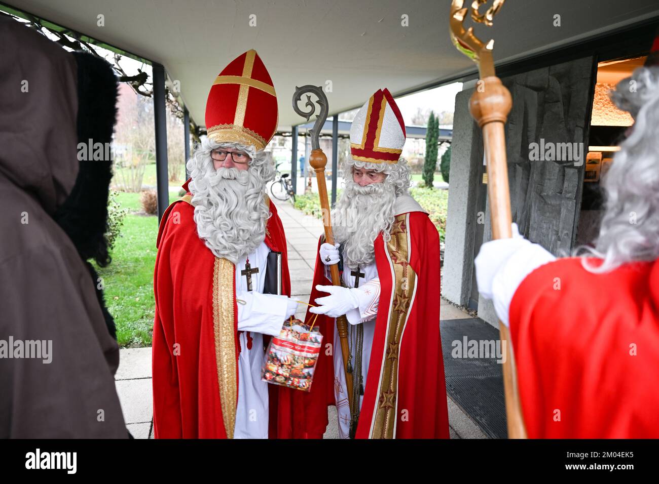 Friedrichshafen, Germany. 04th Dec, 2022. Members of the St. Nicholas Guild Friedrichshafen dressed as St. Nicholas and Knecht Ruprecht stand in front of the Catholic church 'Zum guten Hirten', from where they are sent out. In the days leading up to the 4th of Advent, the guild visits around 150 families, clubs, kindergartens and care facilities. Credit: Felix Kästle/dpa/Alamy Live News Stock Photo