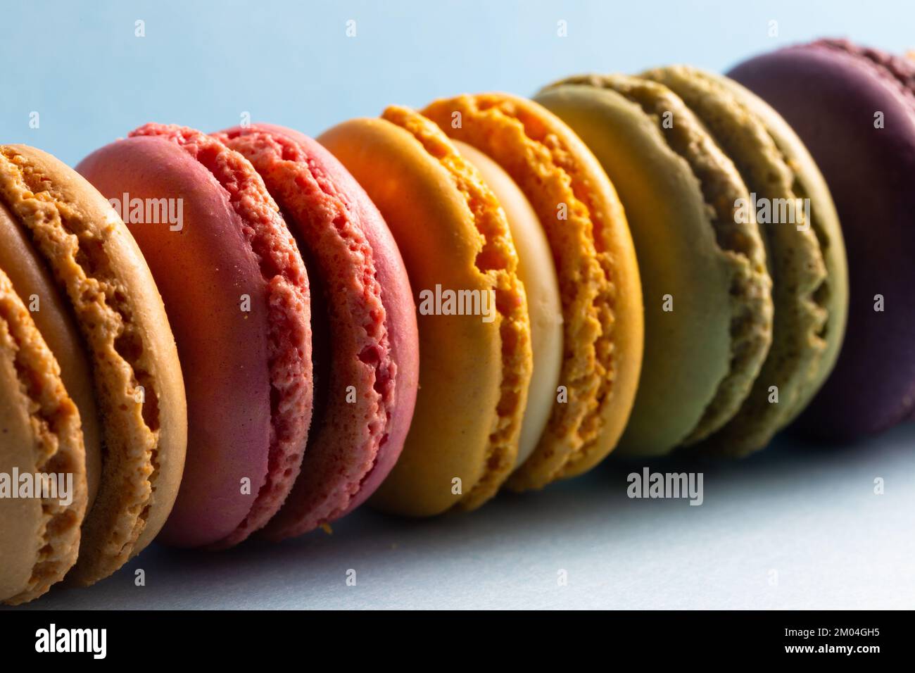 colored macaroons in a row on a blue background Stock Photo