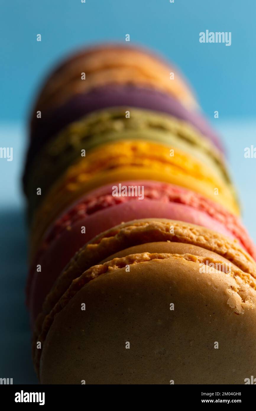 colored macaroons in a row on a blue background Stock Photo