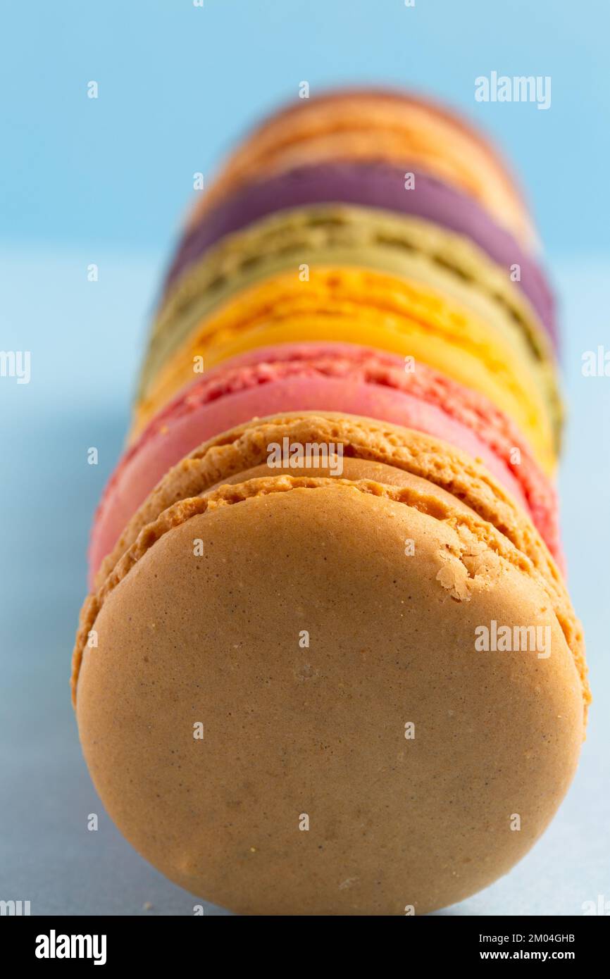 colored macaroons in a row on a blue background Stock Photo