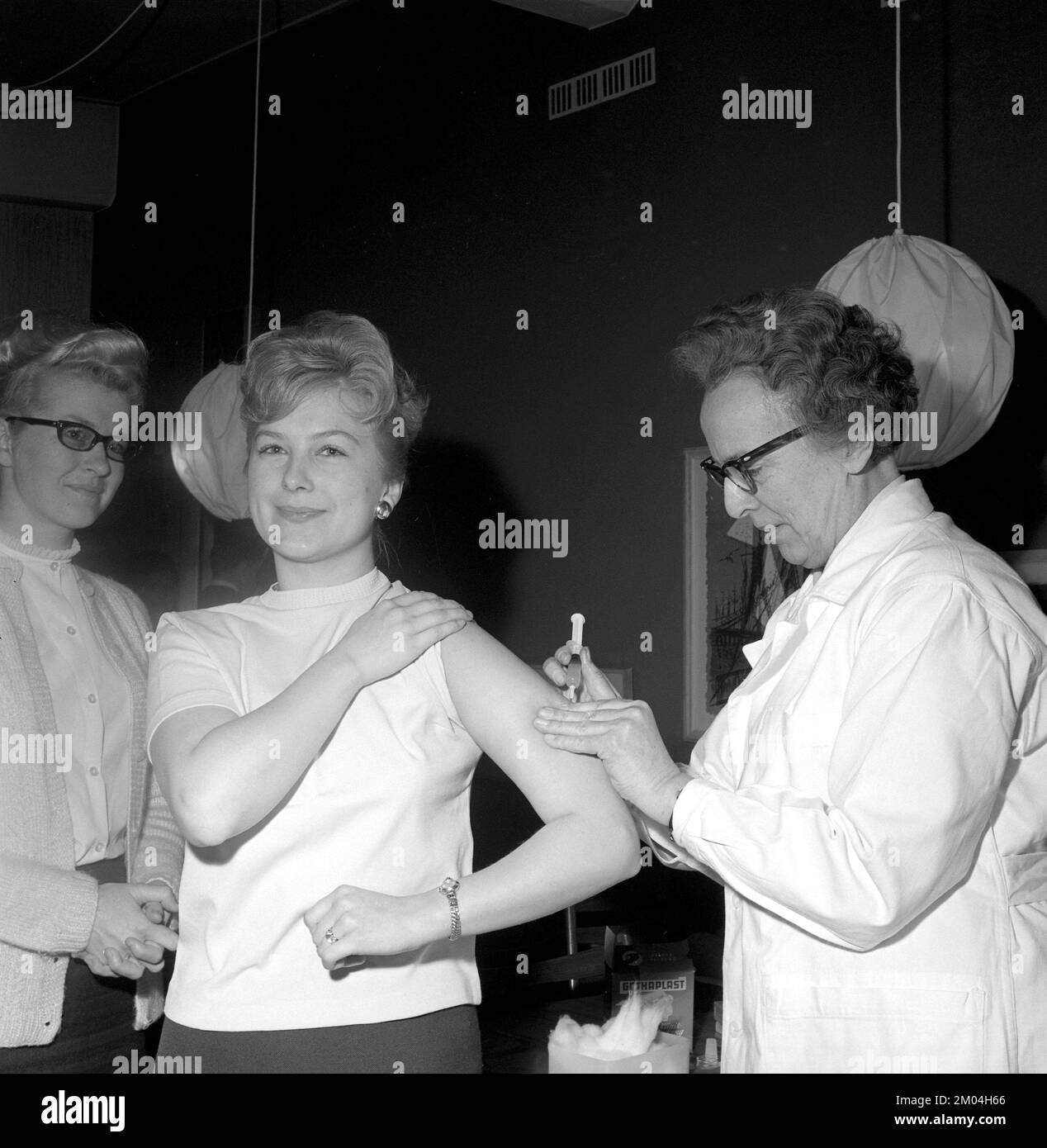 Vaccine in the 1960s. A nurse injects a vaccine in the arm of a young woman. Sweden 1965 Conard ref 5011 Stock Photo